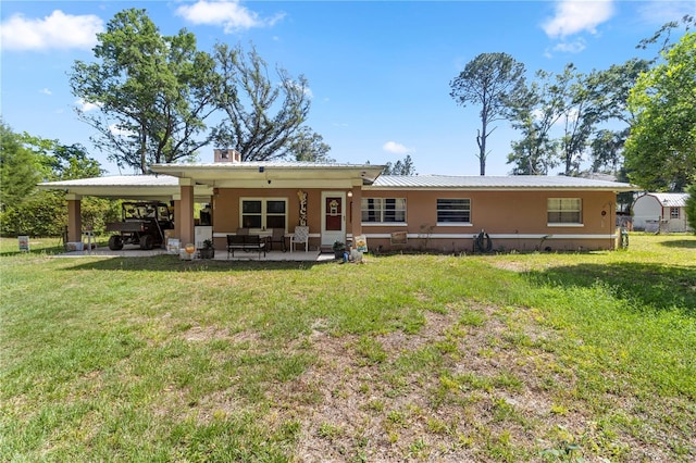 1529 NW 143rd St, Gainesville, FL 32606 - back of house with a yard, metal roof, and an attached carport