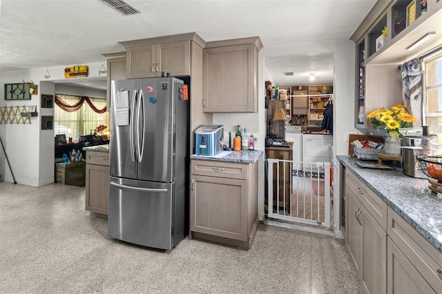 1529 NW 143rd St, Gainesville, FL 32606 - kitchen featuring freestanding refrigerator, washing machine and dryer, light stone counters, and glass insert cabinets