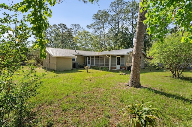 5620 NW 25th St, Gainesville, FL 32653 - back of property with a sunroom, a yard, fence, and metal roof