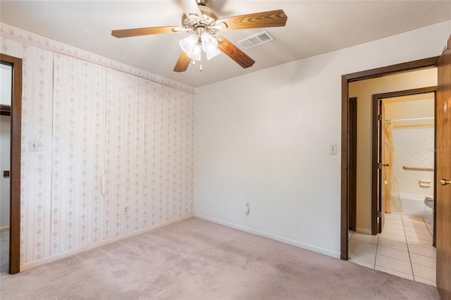 5620 NW 25th St, Gainesville, FL 32653 - unfurnished bedroom featuring baseboards, carpet flooring, ensuite bath, ceiling fan, and visible vents