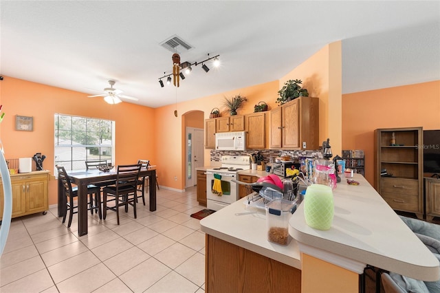 2648 NE 24th Pl, Ocala, FL 34470 - kitchen featuring white appliances, arched walkways, rail lighting, light countertops, and visible vents