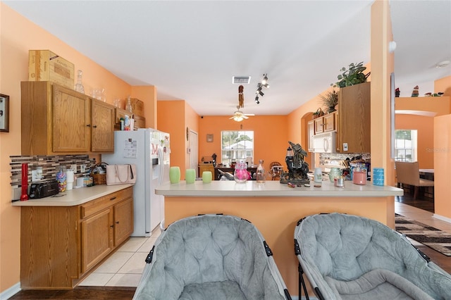2648 NE 24th Pl, Ocala, FL 34470 - kitchen featuring a peninsula, light countertops, backsplash, and white appliances