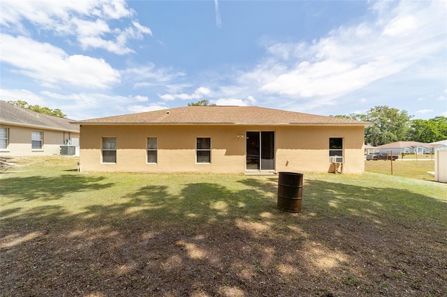 2648 NE 24th Pl, Ocala, FL 34470 - rear view of property featuring a lawn, central AC unit, and stucco siding