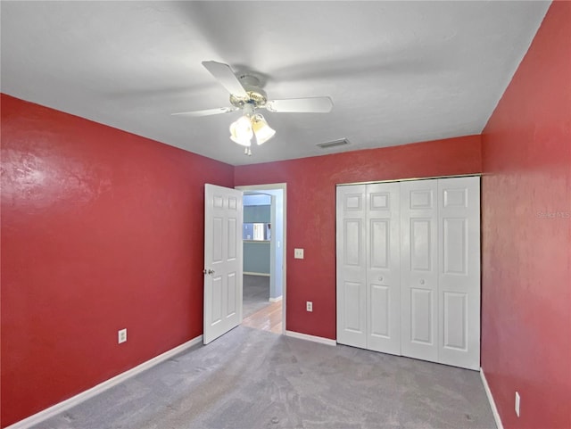 unfurnished bedroom featuring visible vents, a closet, baseboards, ceiling fan, and carpet