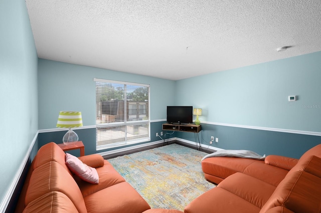 living area with a textured ceiling and baseboards