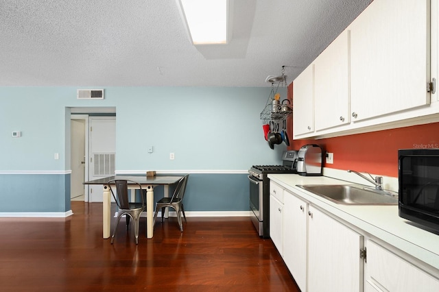 kitchen with stainless steel gas range, visible vents, a sink, light countertops, and white cabinets