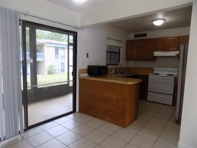 2811 SW Archer Rd Unit W 191, Gainesville, FL 32608 - kitchen with white range with electric stovetop, a peninsula, black microwave, under cabinet range hood, and a sink