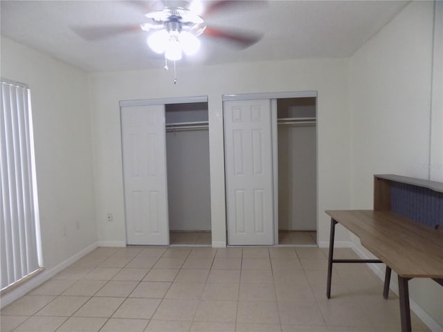 2811 SW Archer Rd Unit W 191, Gainesville, FL 32608 - unfurnished bedroom featuring multiple closets, light tile patterned floors, baseboards, and ceiling fan
