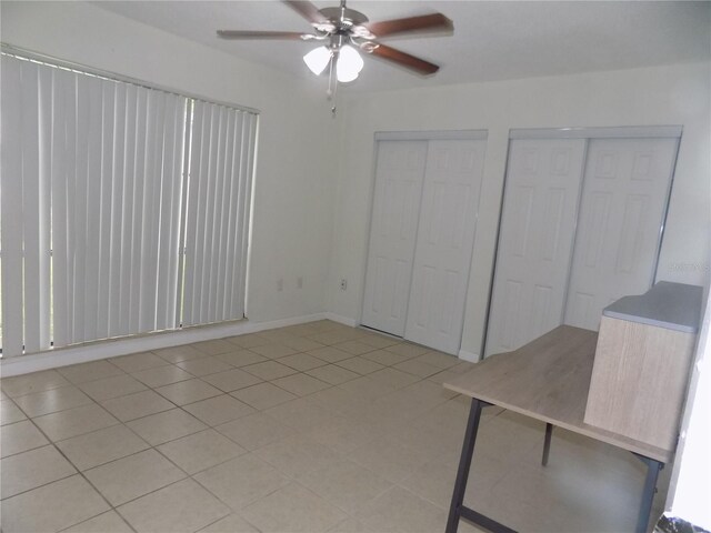 2811 SW Archer Rd Unit W 191, Gainesville, FL 32608 - unfurnished bedroom with two closets, a ceiling fan, and light tile patterned flooring
