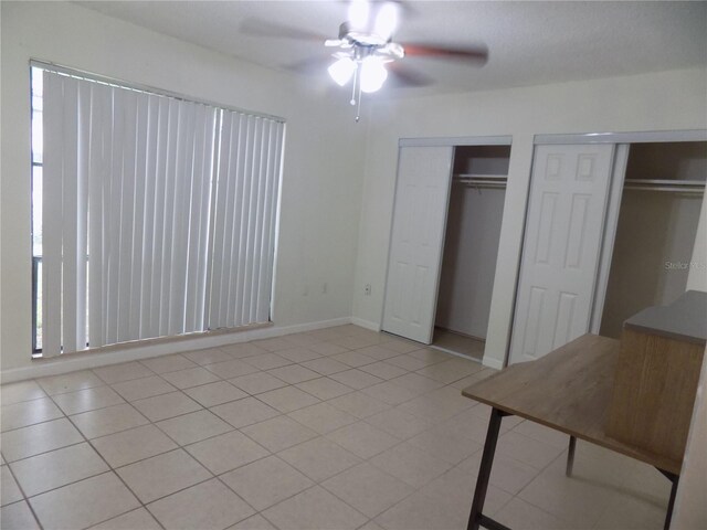 2811 SW Archer Rd Unit W 191, Gainesville, FL 32608 - unfurnished bedroom featuring multiple closets, a ceiling fan, and baseboards