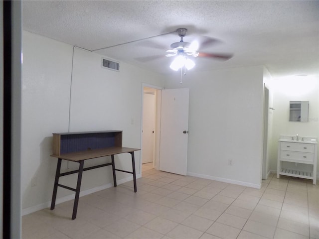 2811 SW Archer Rd Unit W 191, Gainesville, FL 32608 - bedroom with a textured ceiling, baseboards, a sink, and ceiling fan