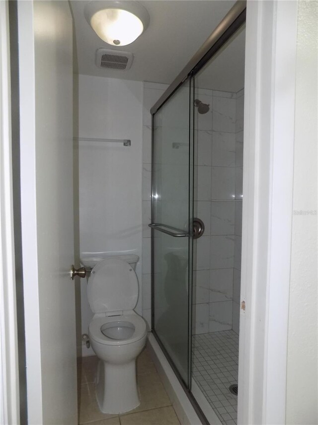 2811 SW Archer Rd Unit W 191, Gainesville, FL 32608 - bathroom featuring tile patterned floors, a shower stall, and toilet