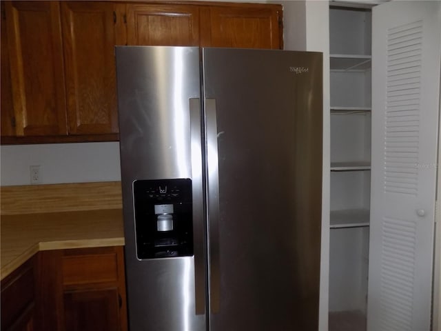 2811 SW Archer Rd Unit W 191, Gainesville, FL 32608 - kitchen with stainless steel fridge with ice dispenser, brown cabinetry, and light countertops