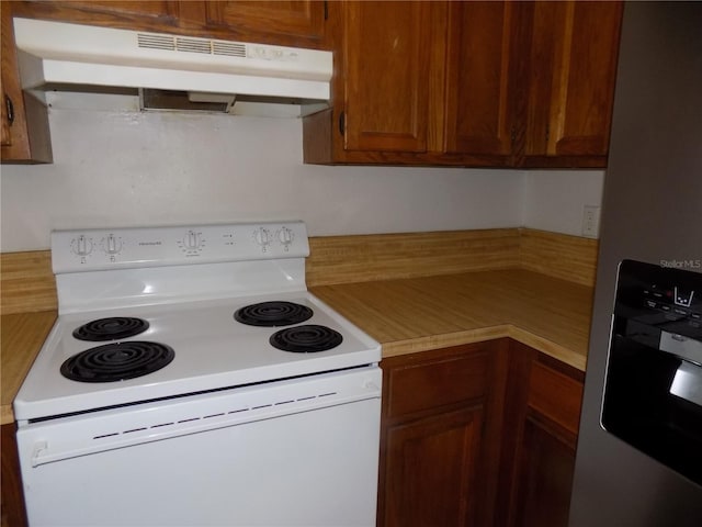 2811 SW Archer Rd Unit W 191, Gainesville, FL 32608 - kitchen with white range with electric stovetop, under cabinet range hood, fridge with ice dispenser, light countertops, and brown cabinets