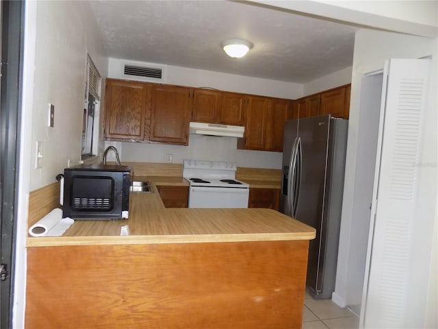 2811 SW Archer Rd Unit W 191, Gainesville, FL 32608 - kitchen featuring white range with electric stovetop, refrigerator with ice dispenser, under cabinet range hood, brown cabinetry, and black microwave