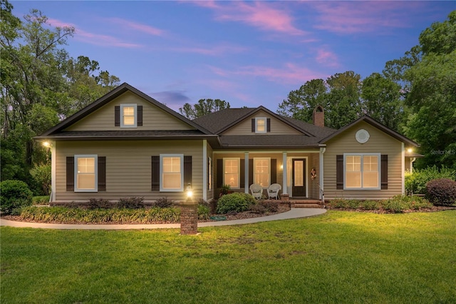 19138 NW 76th Ave, Alachua, FL 32615 - back of house with covered porch, a shingled roof, a chimney, and a lawn