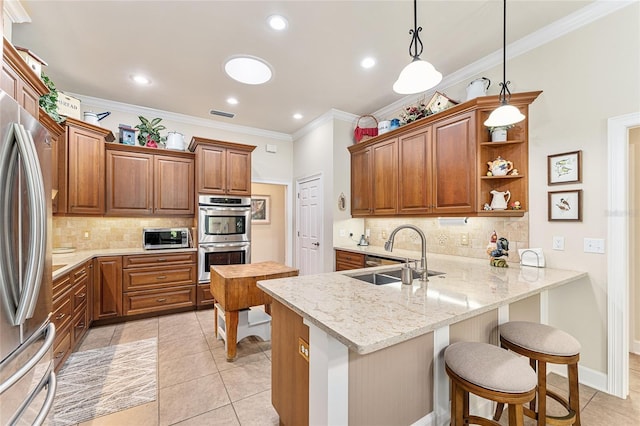 19138 NW 76th Ave, Alachua, FL 32615 - kitchen featuring a breakfast bar, ornamental molding, a sink, a peninsula, and stainless steel appliances