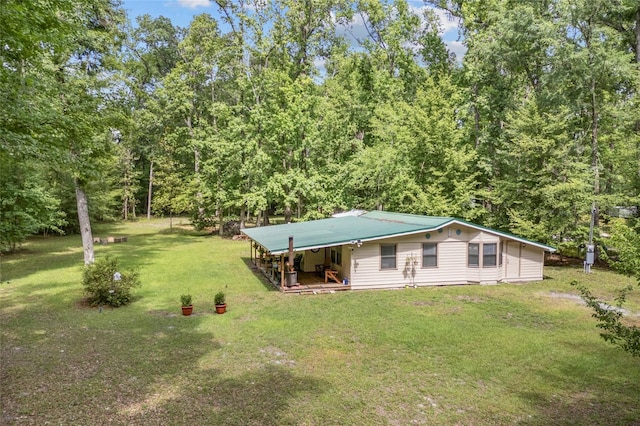 view of front of house with a front lawn and a wooded view