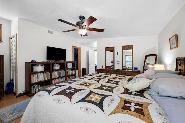 bedroom with visible vents, ceiling fan, and wood finished floors