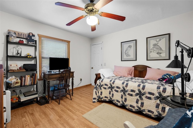 bedroom featuring baseboards, a ceiling fan, and light wood finished floors