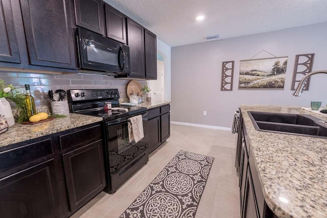 kitchen featuring backsplash, a textured ceiling, visible vents, a sink, and black appliances