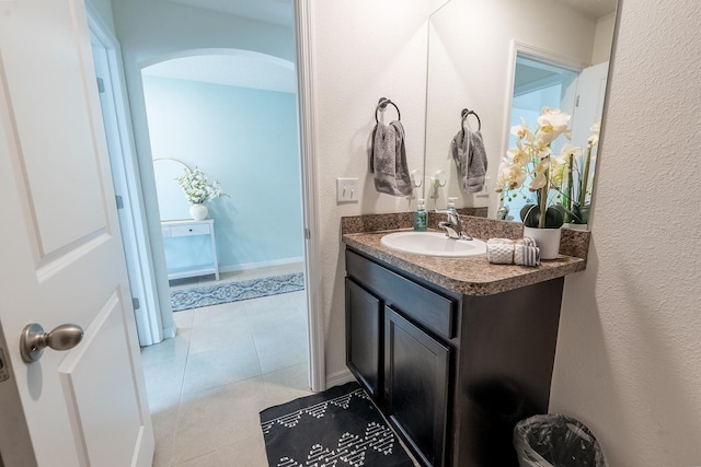 bathroom featuring vanity, a textured wall, and tile patterned flooring