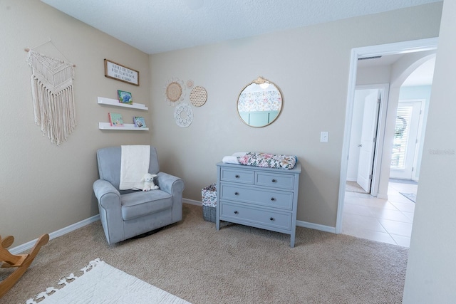 living area with arched walkways, carpet flooring, and baseboards