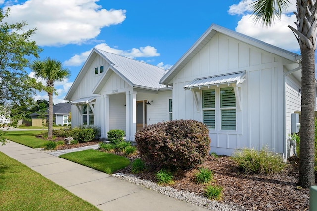 modern farmhouse style home featuring board and batten siding and a front lawn