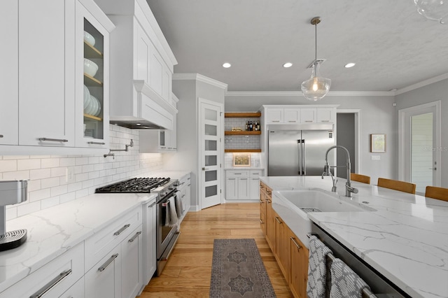kitchen with high quality appliances, a sink, open shelves, recessed lighting, and tasteful backsplash