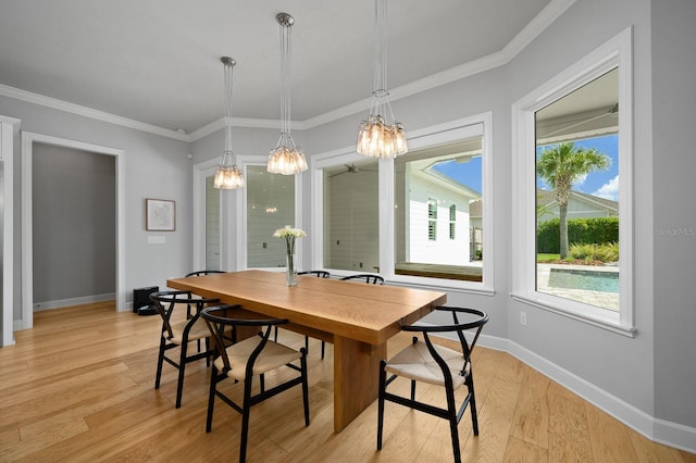 dining space featuring a chandelier, plenty of natural light, light wood-type flooring, baseboards, and crown molding