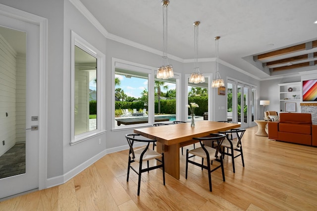 dining space featuring light wood-style flooring, baseboards, ornamental molding, and a chandelier