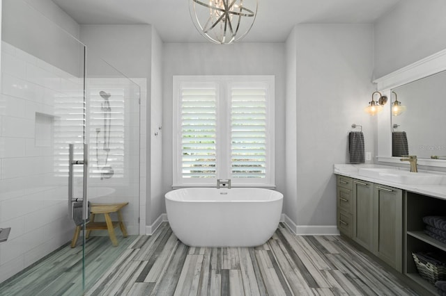 bathroom with vanity, a shower stall, a freestanding bath, and wood finished floors