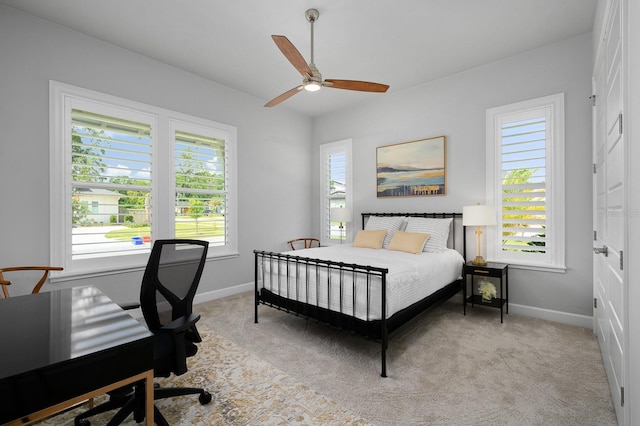 bedroom featuring baseboards, light colored carpet, a desk, and ceiling fan