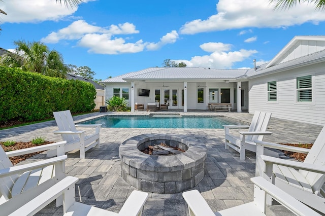 view of pool featuring a fire pit, french doors, and a patio