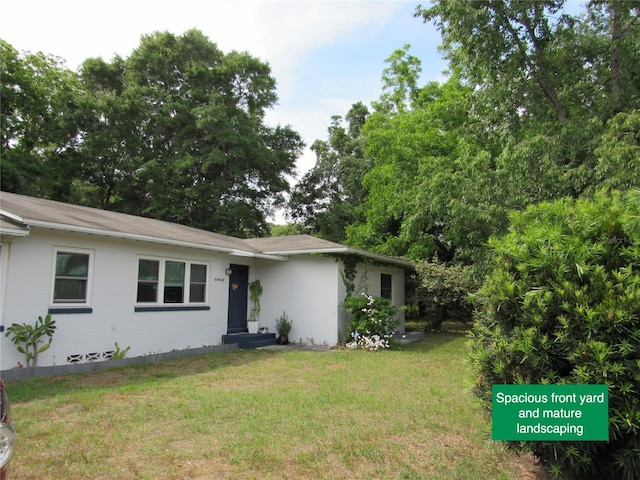 ranch-style home with roof with shingles and a front lawn