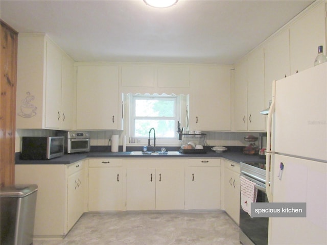 kitchen featuring dark countertops, stainless steel appliances, and a sink