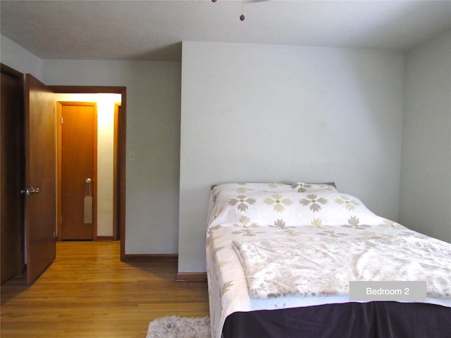 bedroom featuring light wood-style flooring and baseboards