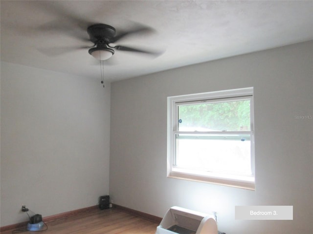 unfurnished room featuring light wood-style flooring, baseboards, and a ceiling fan