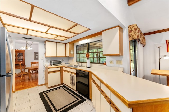 7022 NW 51st Ter, Gainesville, FL 32653 - kitchen with a peninsula, black dishwasher, freestanding refrigerator, an inviting chandelier, and light countertops
