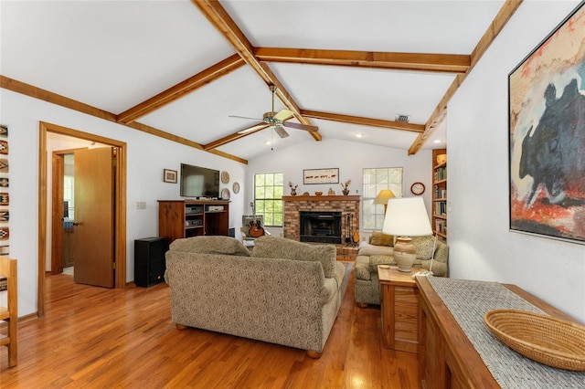 7022 NW 51st Ter, Gainesville, FL 32653 - living room with lofted ceiling with beams, light wood-type flooring, visible vents, ceiling fan, and a brick fireplace