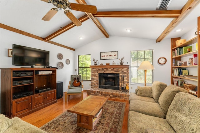 7022 NW 51st Ter, Gainesville, FL 32653 - living area with a ceiling fan, lofted ceiling with beams, a brick fireplace, light wood-type flooring, and visible vents