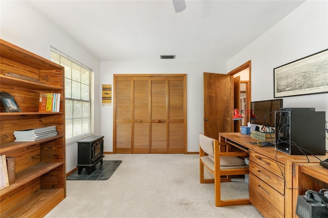 7022 NW 51st Ter, Gainesville, FL 32653 - office space with a wood stove, light carpet, baseboards, and visible vents