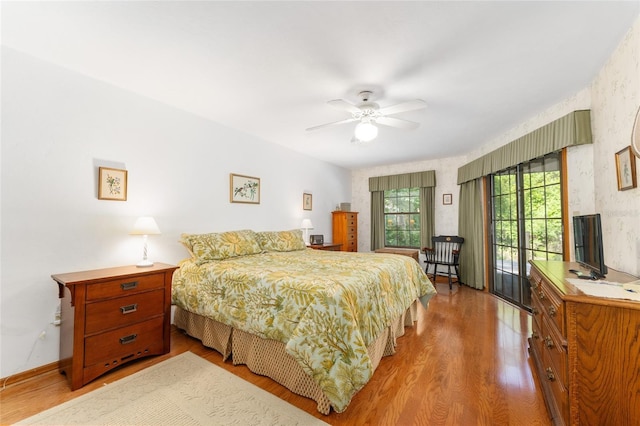 7022 NW 51st Ter, Gainesville, FL 32653 - bedroom with wallpapered walls, access to outside, wood finished floors, and ceiling fan