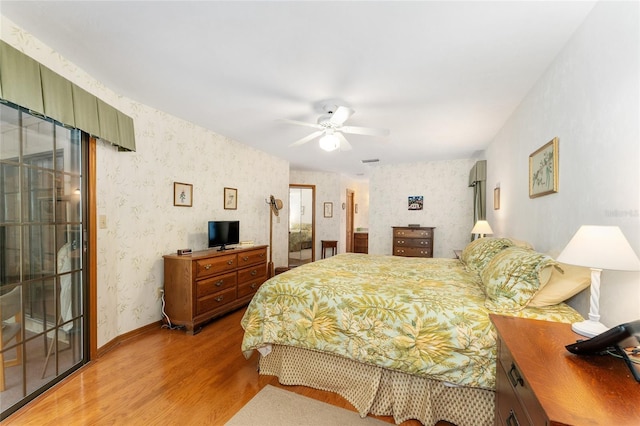 7022 NW 51st Ter, Gainesville, FL 32653 - bedroom with ceiling fan, wallpapered walls, and wood finished floors