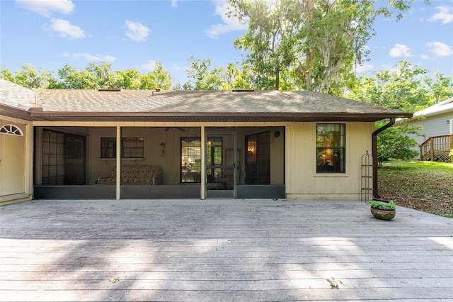 7022 NW 51st Ter, Gainesville, FL 32653 - rear view of property with a sunroom, a shingled roof, and a wooden deck