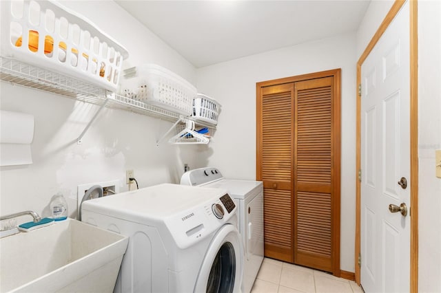 7022 NW 51st Ter, Gainesville, FL 32653 - washroom featuring laundry area, light tile patterned floors, washing machine and clothes dryer, and a sink
