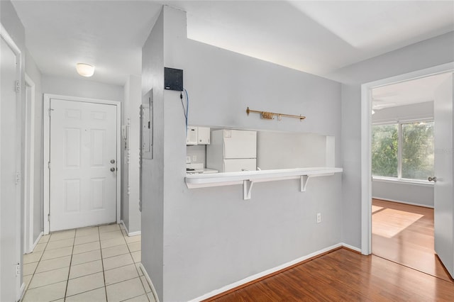 4000 SW 23rd St Unit 2-305, Gainesville, FL 32608 - kitchen featuring white appliances, white cabinets, light countertops, light wood-style floors, and electric panel