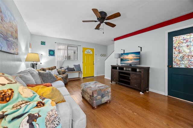 living area featuring wood finished floors, ceiling fan, and baseboards