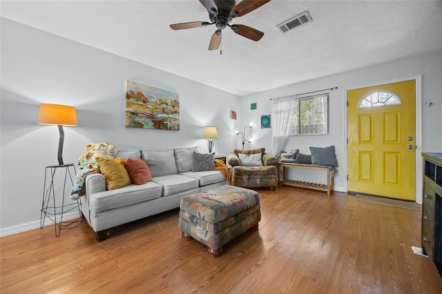 living room with wood finished floors, a ceiling fan, and baseboards