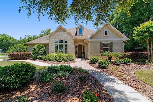 view of front of house with stone siding and roof with shingles
